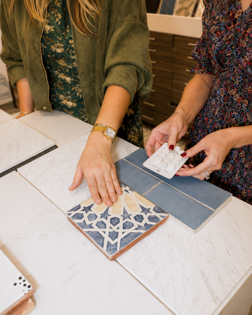 Hands compare tile samples during a design review at the Famosa Tile showroom in Costa Mesa.