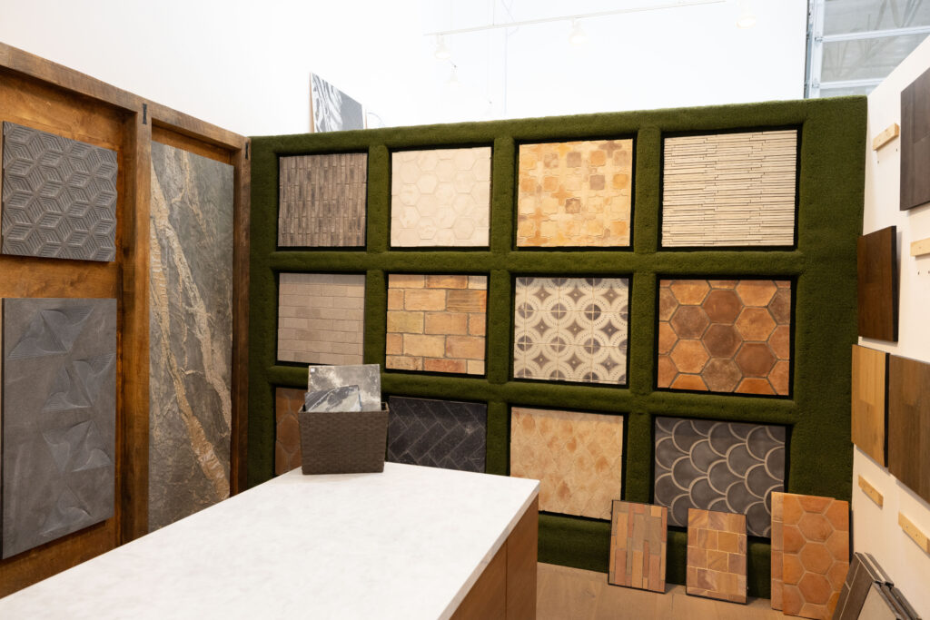 Famosa Tile Costa Mesa showroom displaying new fall 2026 tile arrivals in deep green, terracotta, warm charcoal, and earthy limestone tones.